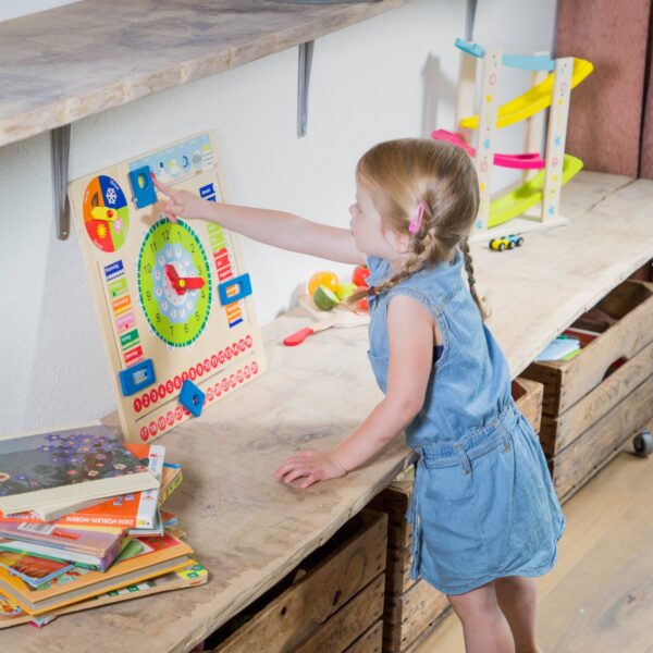 kind-speelt-met-houten-kalenderklok Kind leert tijd en datum met kalenderklok van hout