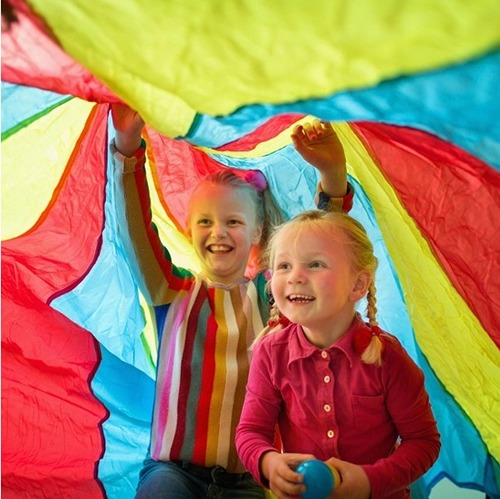 Twee kinderen onder de parachute van BS Toys
