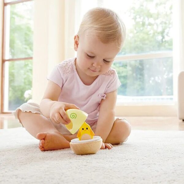 montessori-hape-wonder-tuimelaar-stapeltoren-peuter.jpg Peuter speelt op grond met Hape wobble tuimelaar Het Speellab