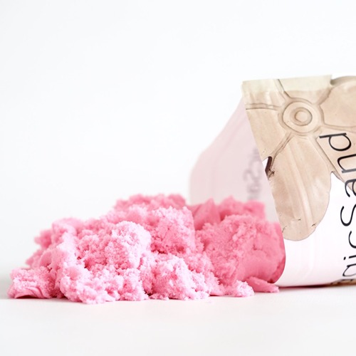 De zak kinetisch zand Sensoryfun op zijn kant waar roze zand eruit ligt